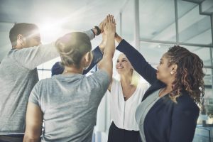 Shot of a diverse group of coworkers high fiving together in an office